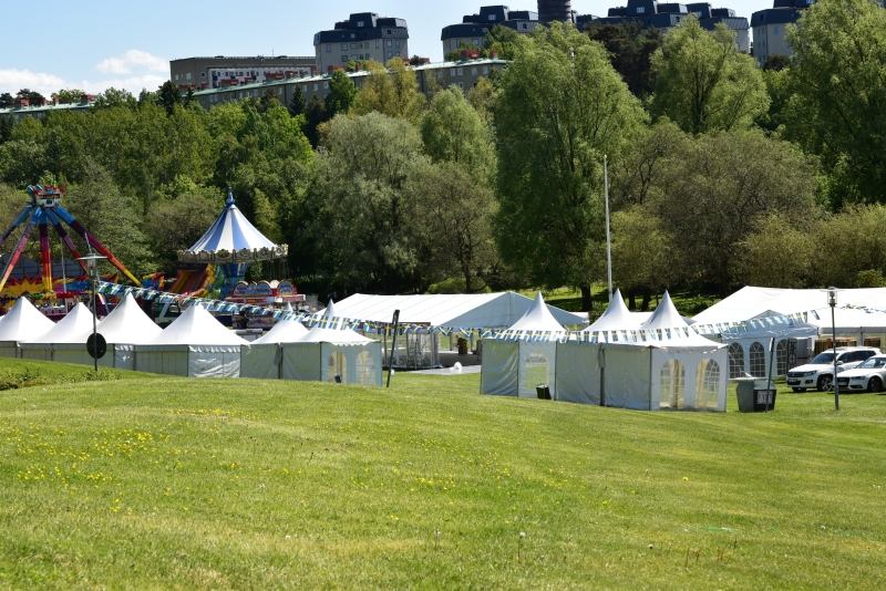 Vy över Golfängarna på Nationaldagen. Flera tält står uppställda och ett tivoli syns i bakgrunden